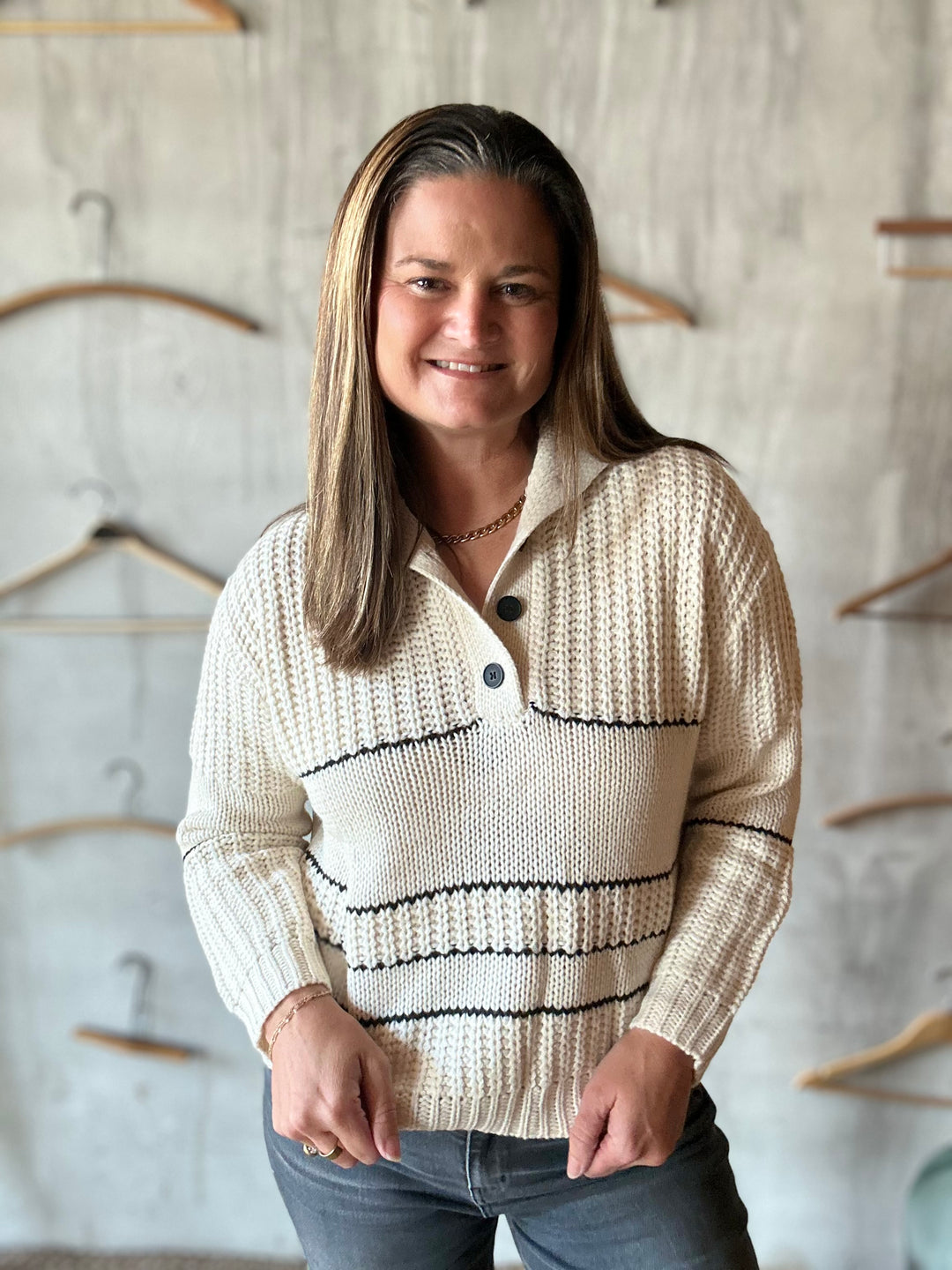 Close-up of a cream collared sweater with black button placket