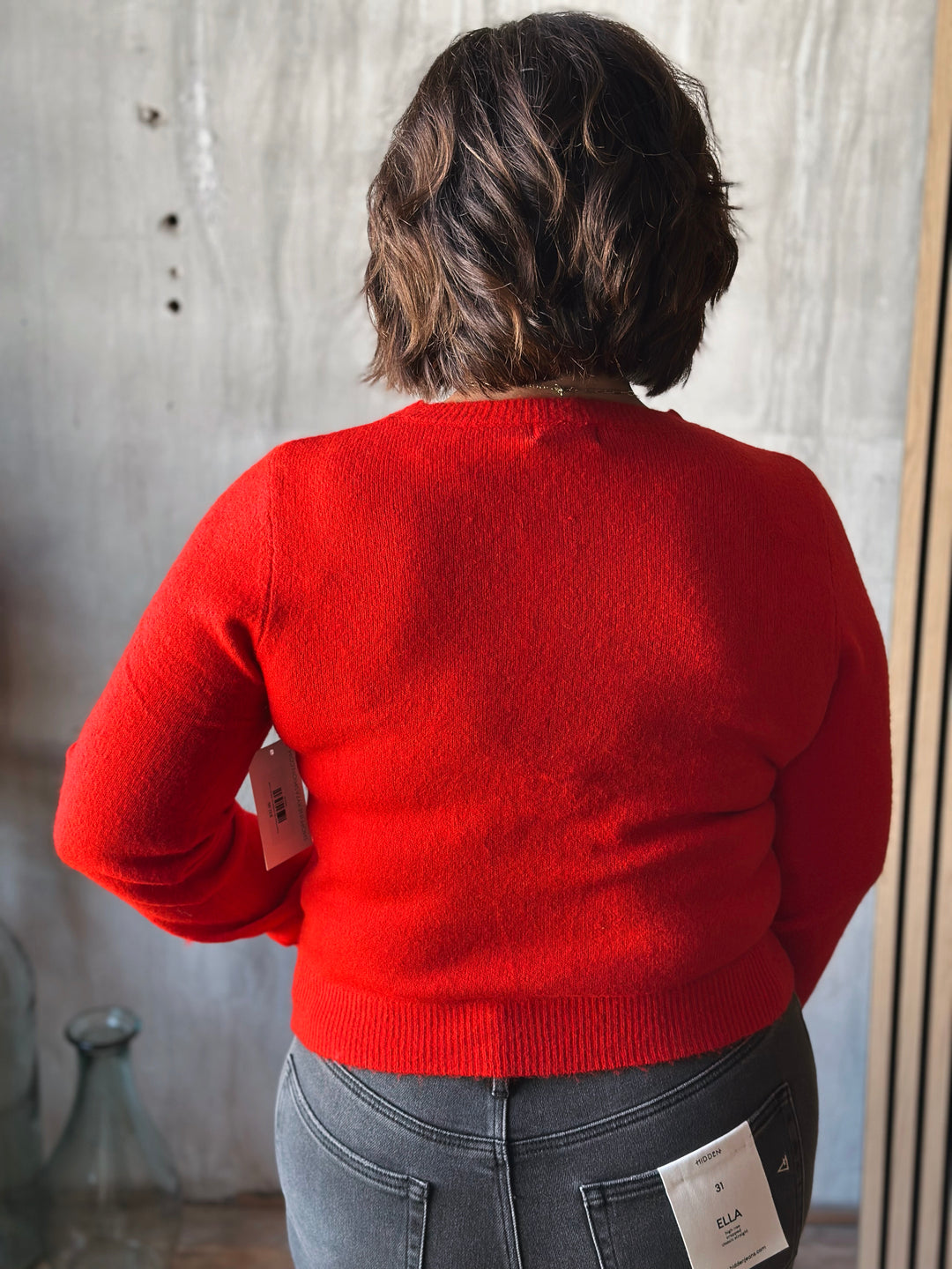 Person wearing a red sweater with a blurred background