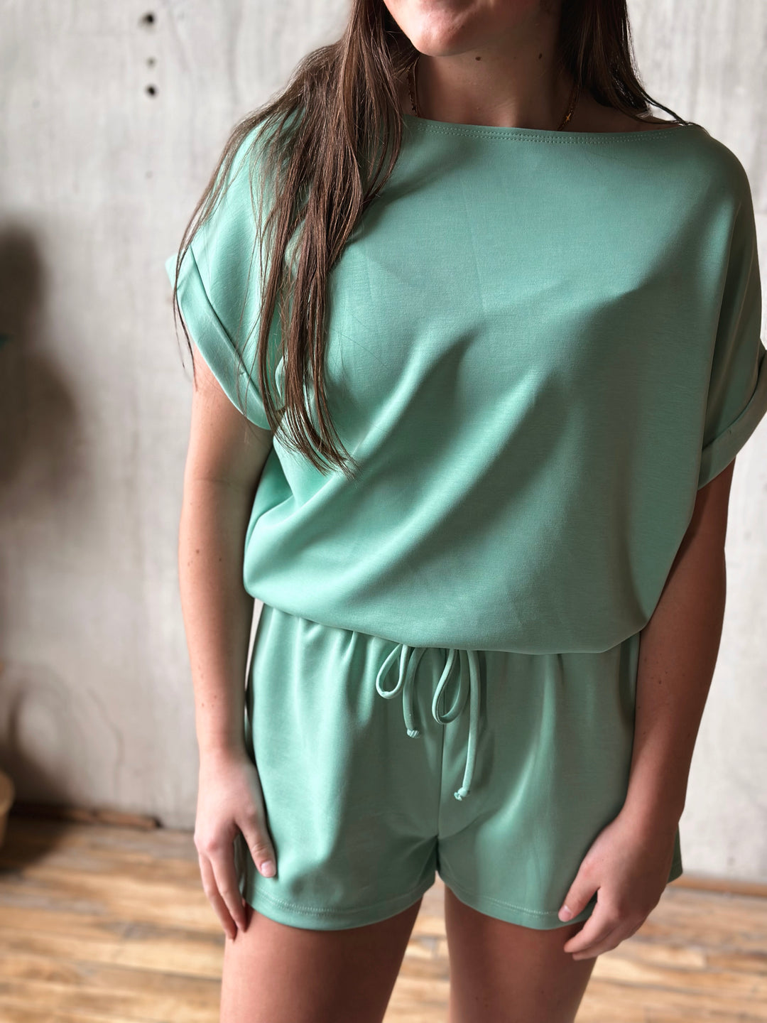 Person wearing a mint green outfit with a loose-fitting top and shorts.