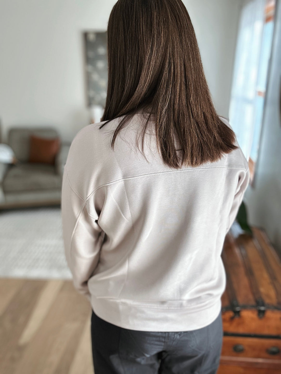 Person wearing a light gray sweatshirt in an indoor setting