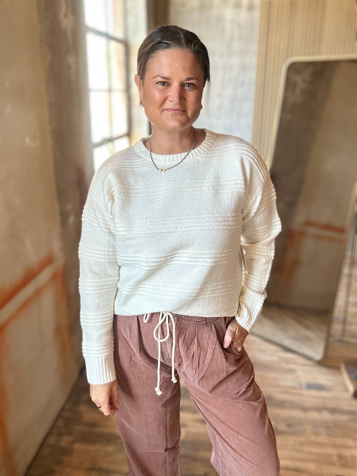 Cream textured-stripe sweater styled with mauve drawstring pants