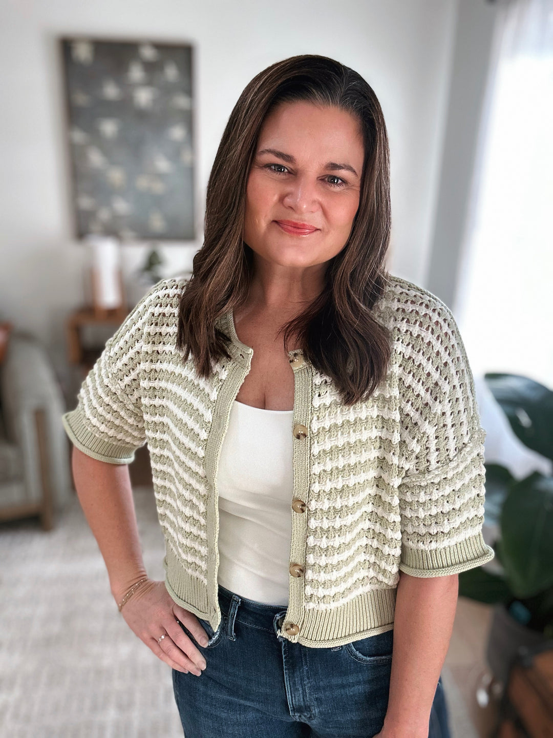 Woman wearing a light green knitted cardigan in a home setting