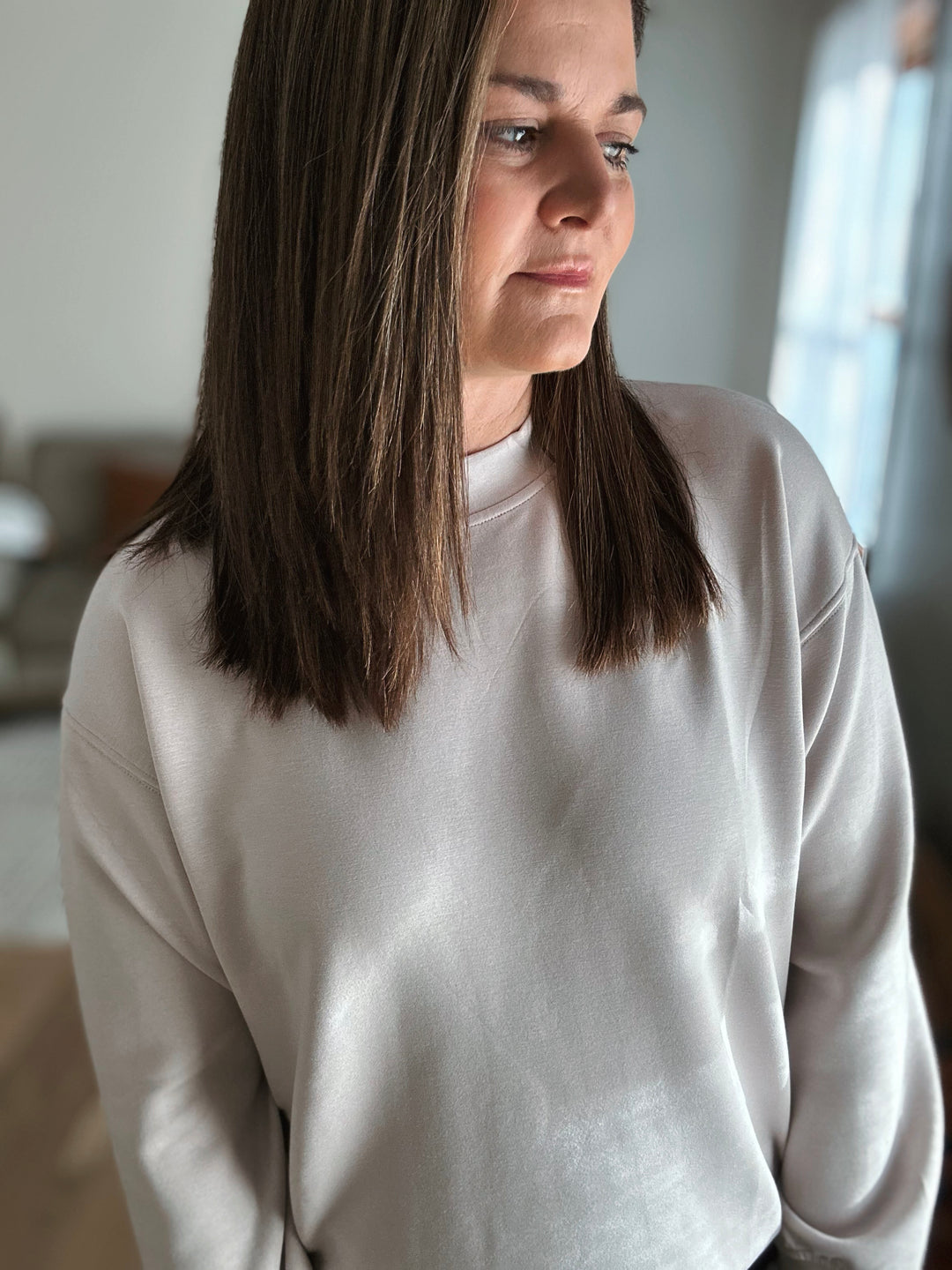 Person wearing a light gray sweatshirt indoors