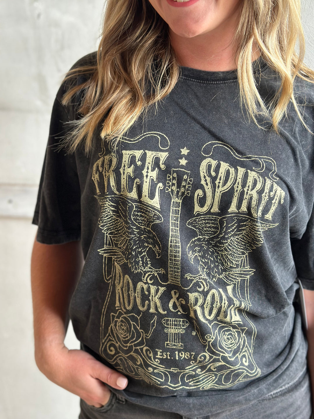 Close-up of a faded charcoal graphic tee with a Free Spirit rock and roll print