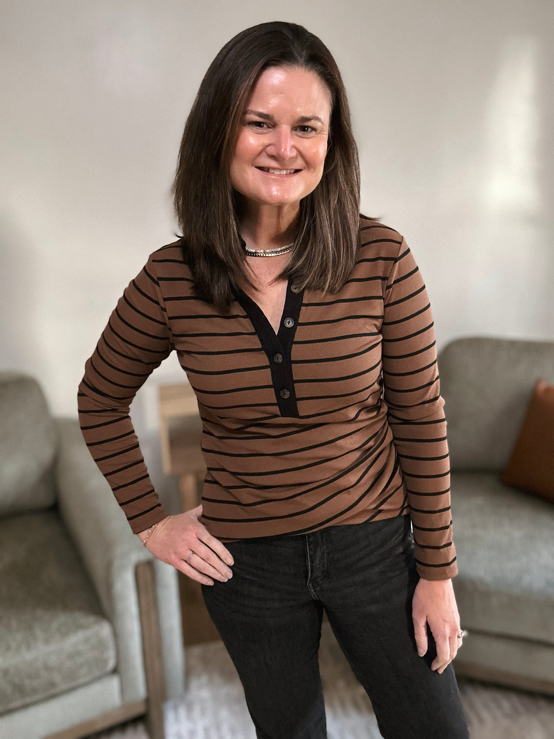 Woman wearing a brown striped shirt in a living room setting