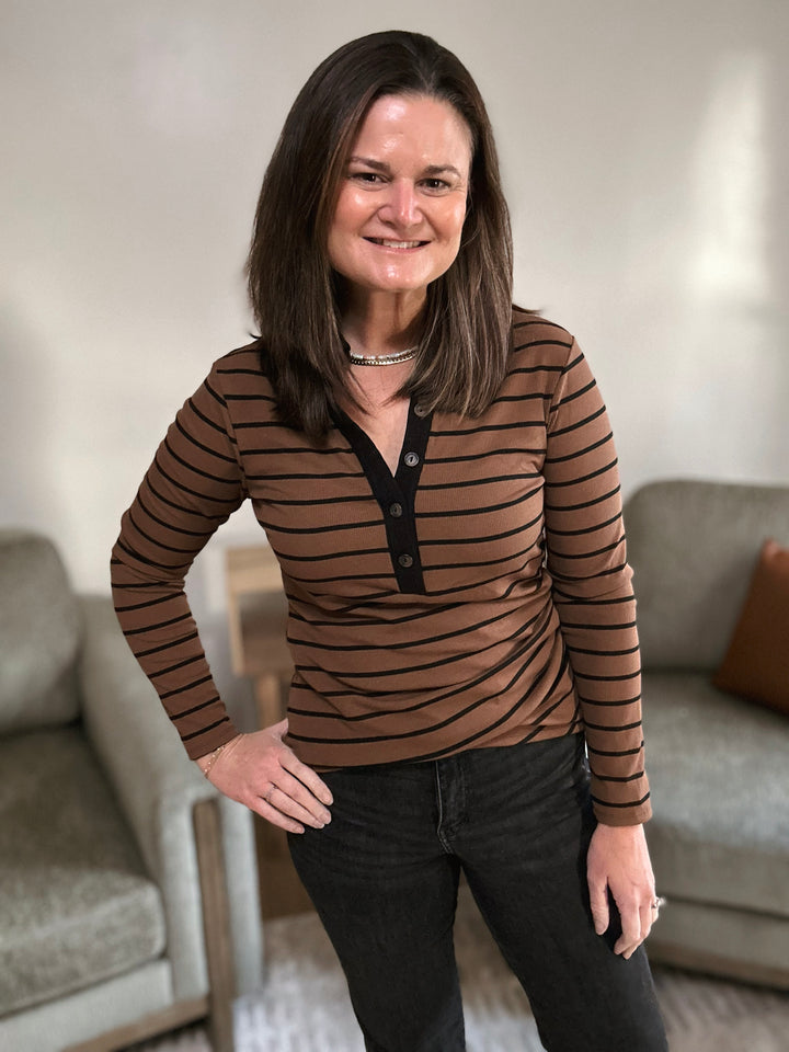 Woman wearing a brown striped shirt in a living room setting