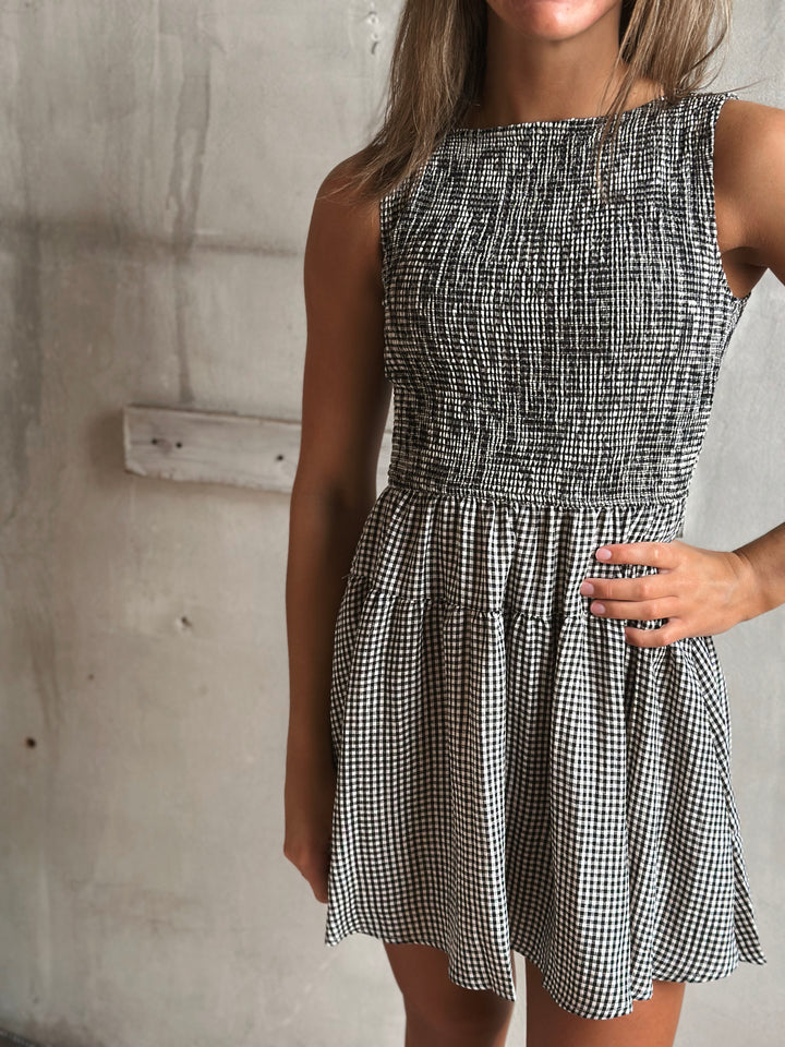 Black and white gingham dress worn by a person against a plain background.