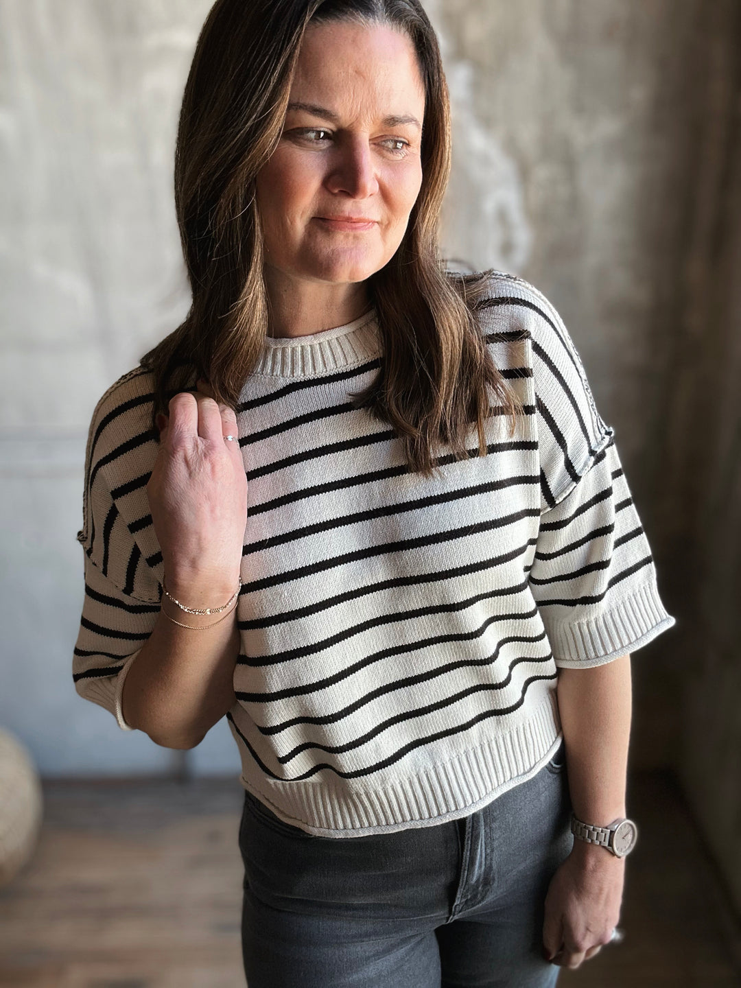 Woman wearing a black and white striped sweater in an indoor setting