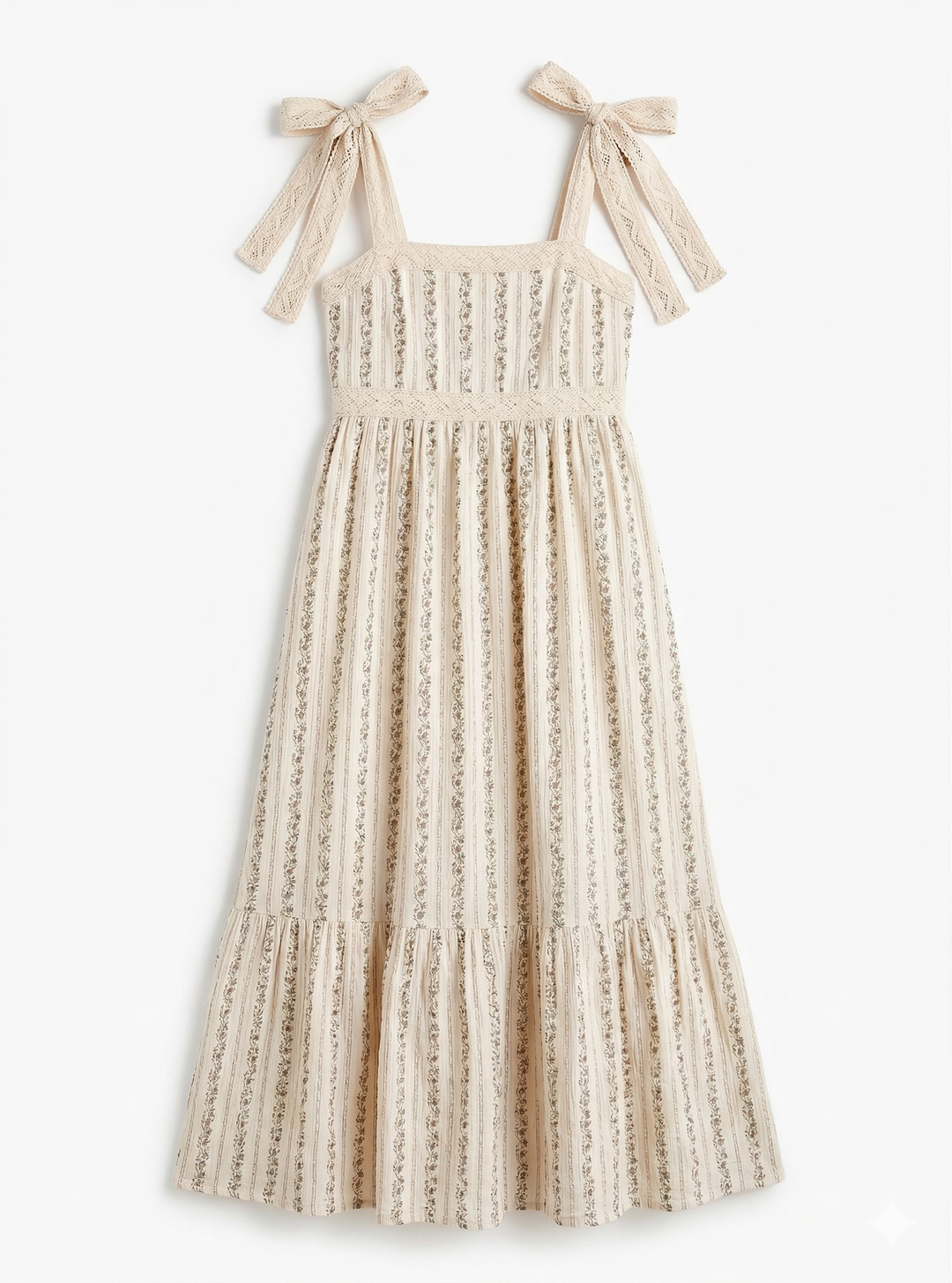 Beige dress with floral designs and bow straps on a white background.
