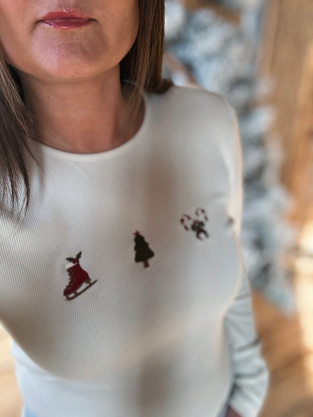Person wearing a white sweater with Christmas-themed designs.