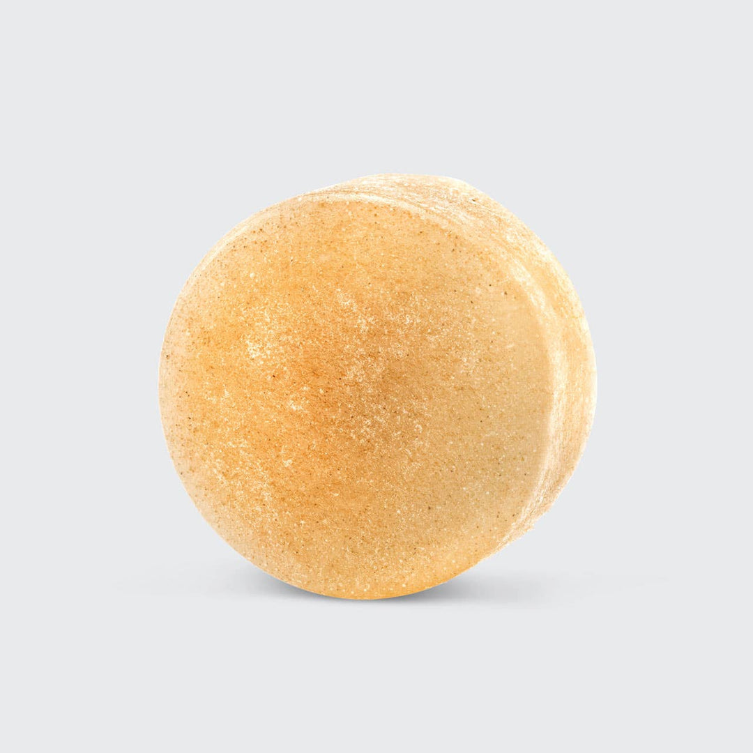 Round beige bath bomb on a light gray background