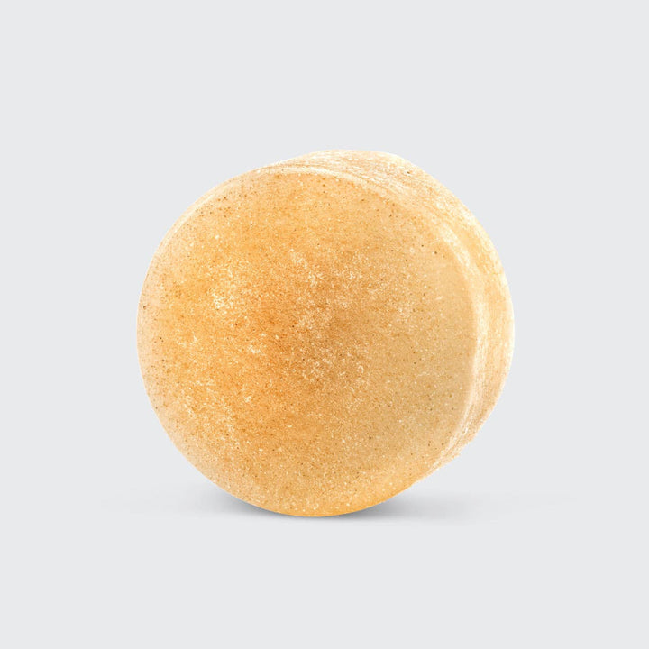 Round beige bath bomb on a light gray background
