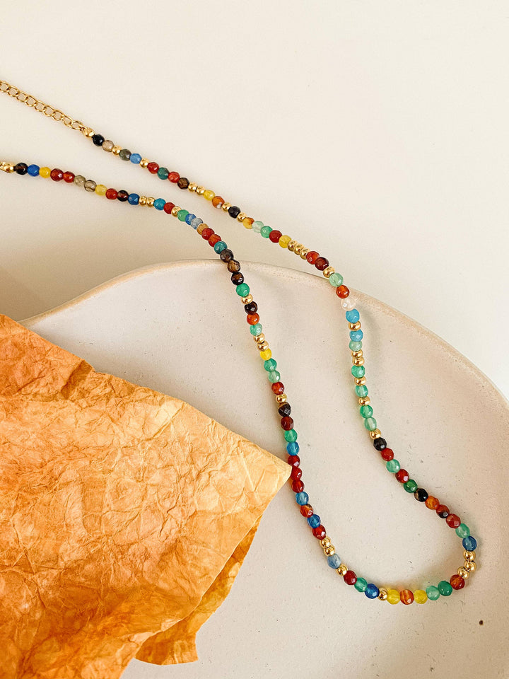 Colorful beaded necklace on a textured surface