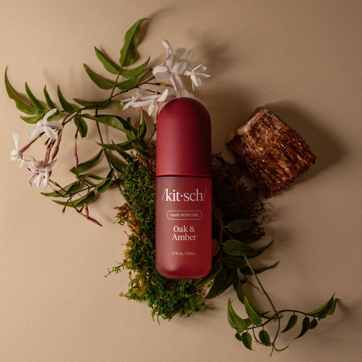 Kitsch hair perfume bottle with floral and leaf elements on a beige background