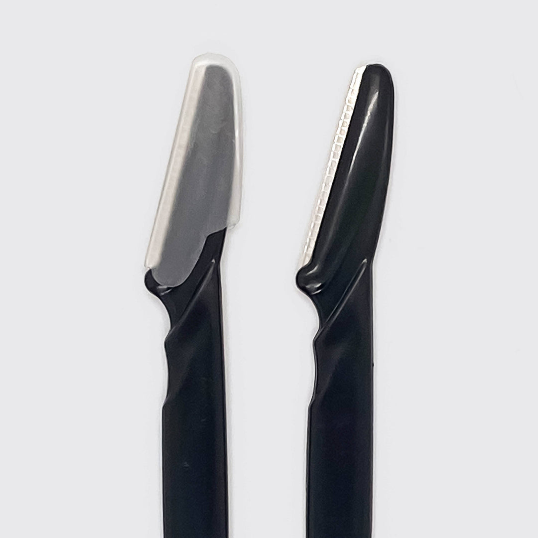 Two black razors with silver blades on a light gray background