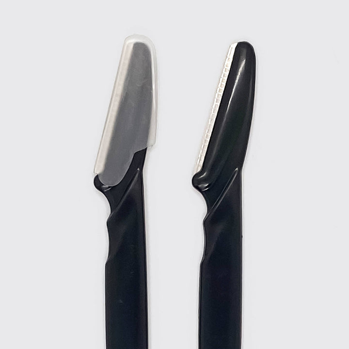 Two black razors with silver blades on a light gray background