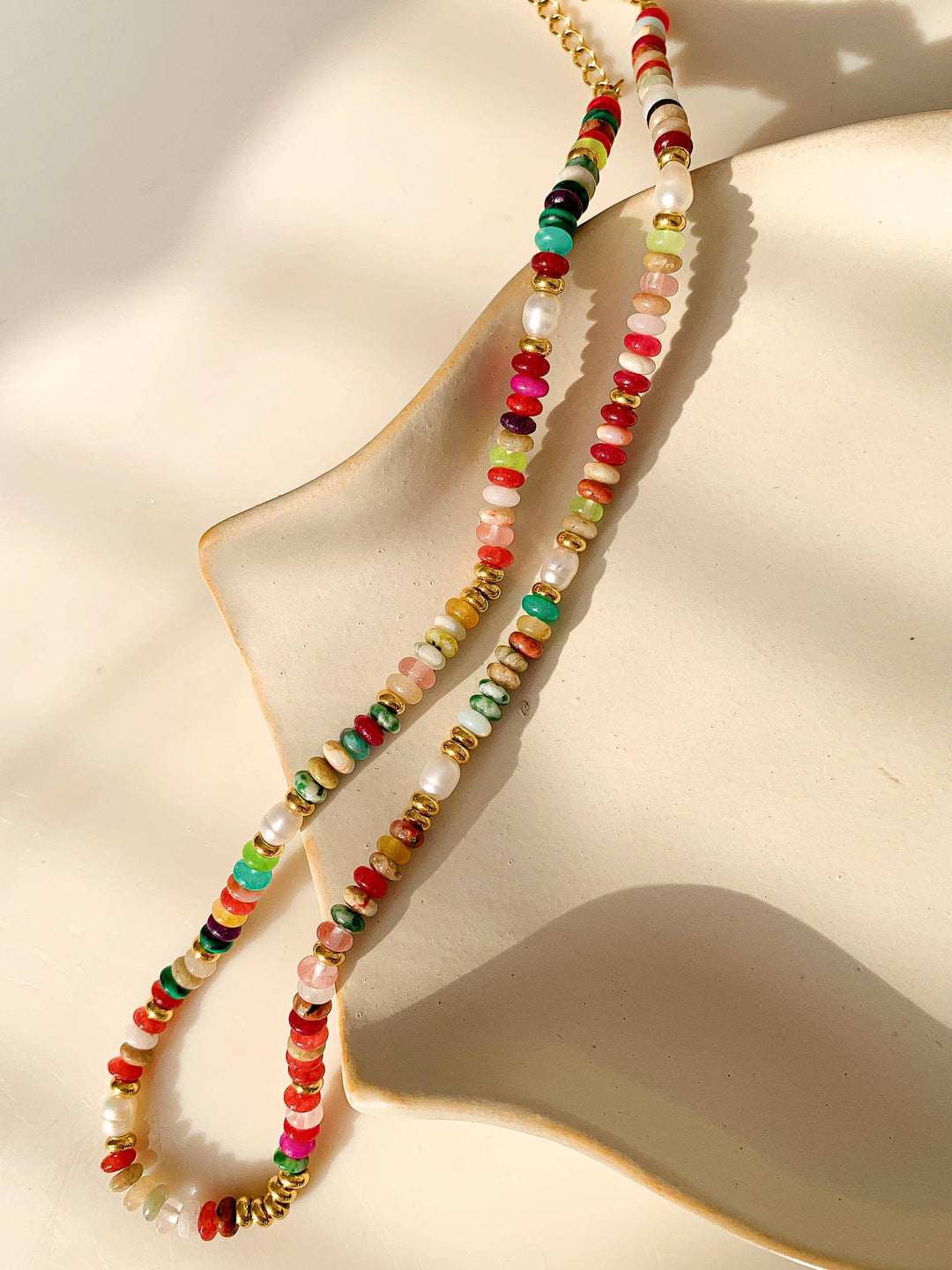 Colorful beaded necklace on a beige surface