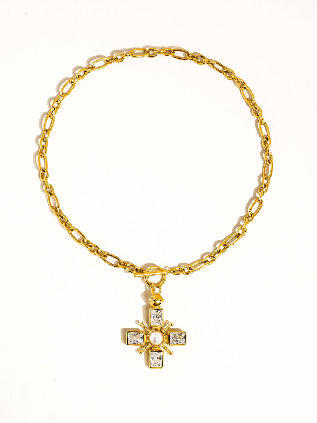 Gold bracelet with a cross pendant on a white background