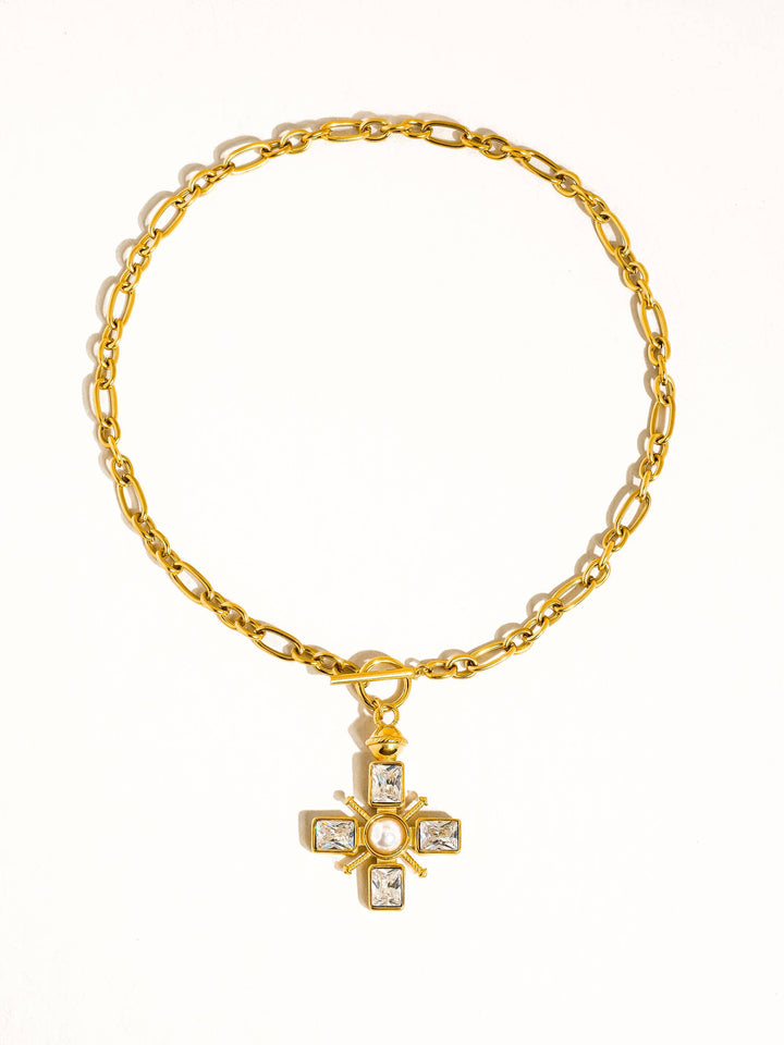 Gold bracelet with a cross pendant on a white background
