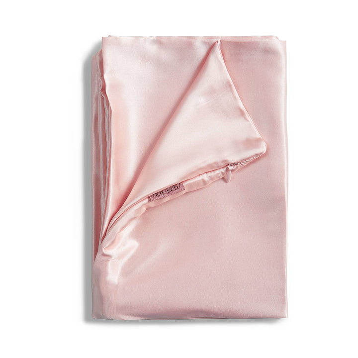 Folded pink satin sheet on a white background