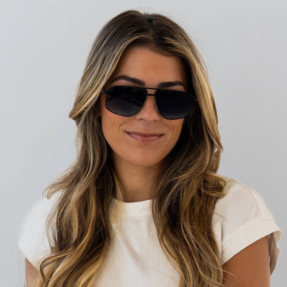 Woman wearing sunglasses with a plain background