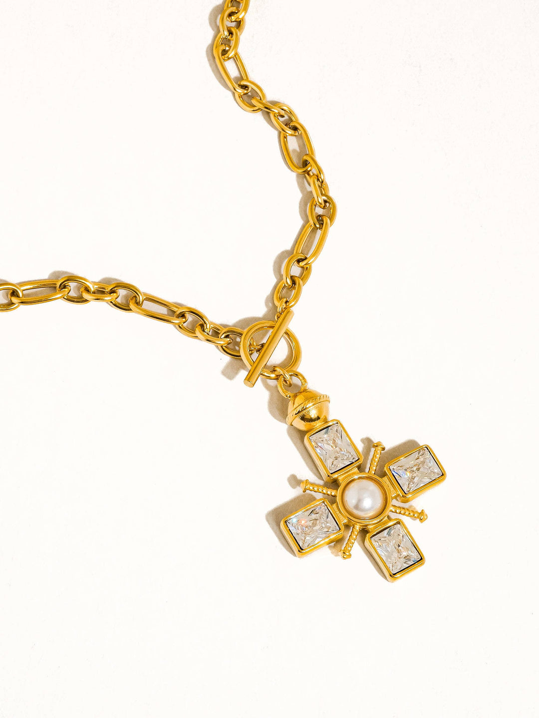 Gold bracelet with a decorative clasp on a white background