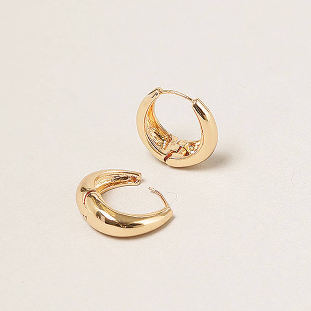 Gold hoop earrings on a light beige background