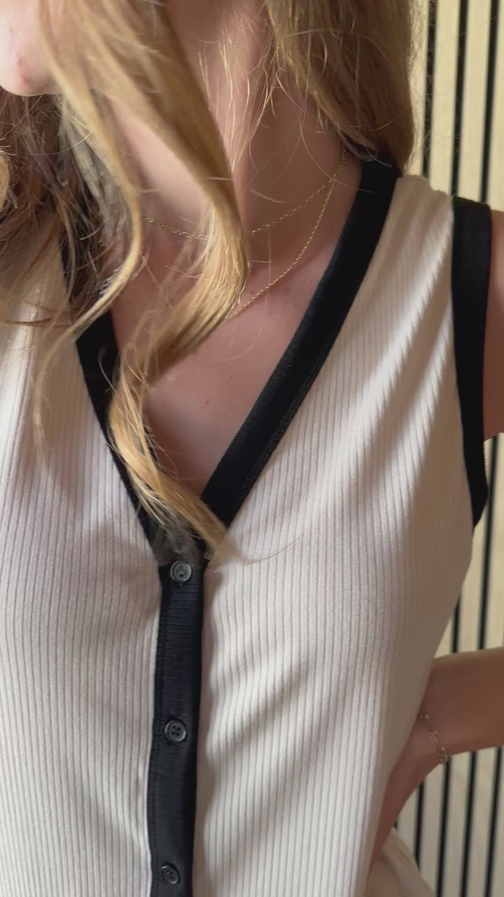 Video of what model wearing sleeveless V-neck top with functional front button down and ribbed knit fabric 
